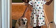 Major is registered to the contest to win money with this photo: animal, child, clothing, dog, door, dress, expression, floor, hallway, happy, indoor, light, person, petting, shoes, short_sleeves, smiling, socks, wooden_floor, young
