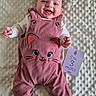 baby, smiling, infant, pink_overall, cat_design, white_blanket, milestone_card, lying_down, cute, happy, socks, baby_clothes, portrait, child, indoors, soft_texture, celebration, three_months, cute_outfit, joy
