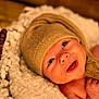 baby, infant, hat, knit_hat, blanket, white_blanket, smile, happy, face, eyes, skin, newborn, cute, portrait, closeup, warm_lighting, soft_texture, cozy, child, indoors