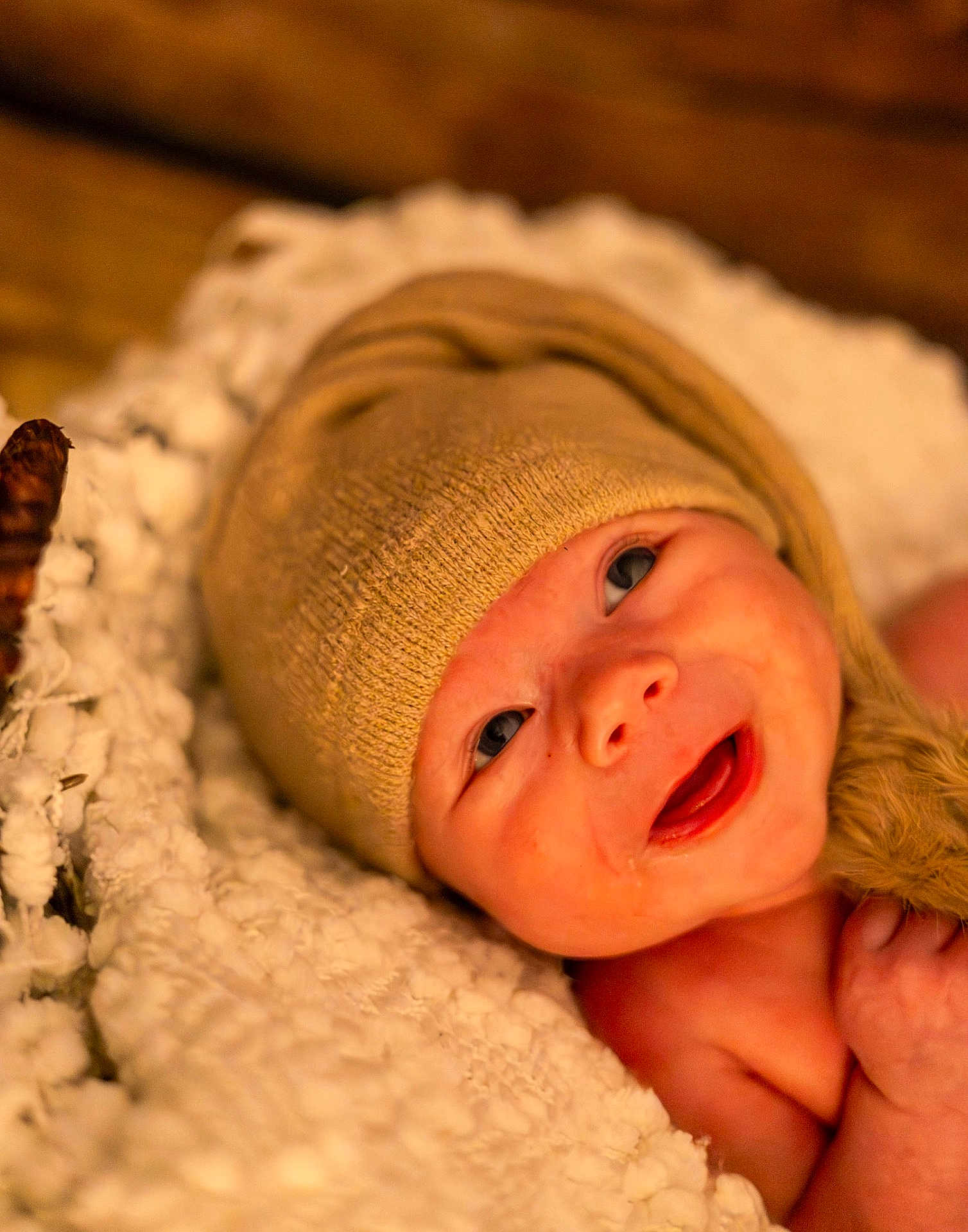 Xavier is registered to the contest to win money with this photo: baby, infant, hat, knit_hat, blanket, white_blanket, smile, happy, face, eyes, skin, newborn, cute, portrait, closeup, warm_lighting, soft_texture, cozy, child, indoors