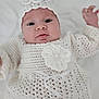 Ashley joined the competition — help win amazing prizes! baby, infant, crochet, white_clothing, headband, hand, face, cute, portrait, newborn, child, soft_texture, fabric, ribbon, closeup, small_hand, lying_down, indoors, adorable, person