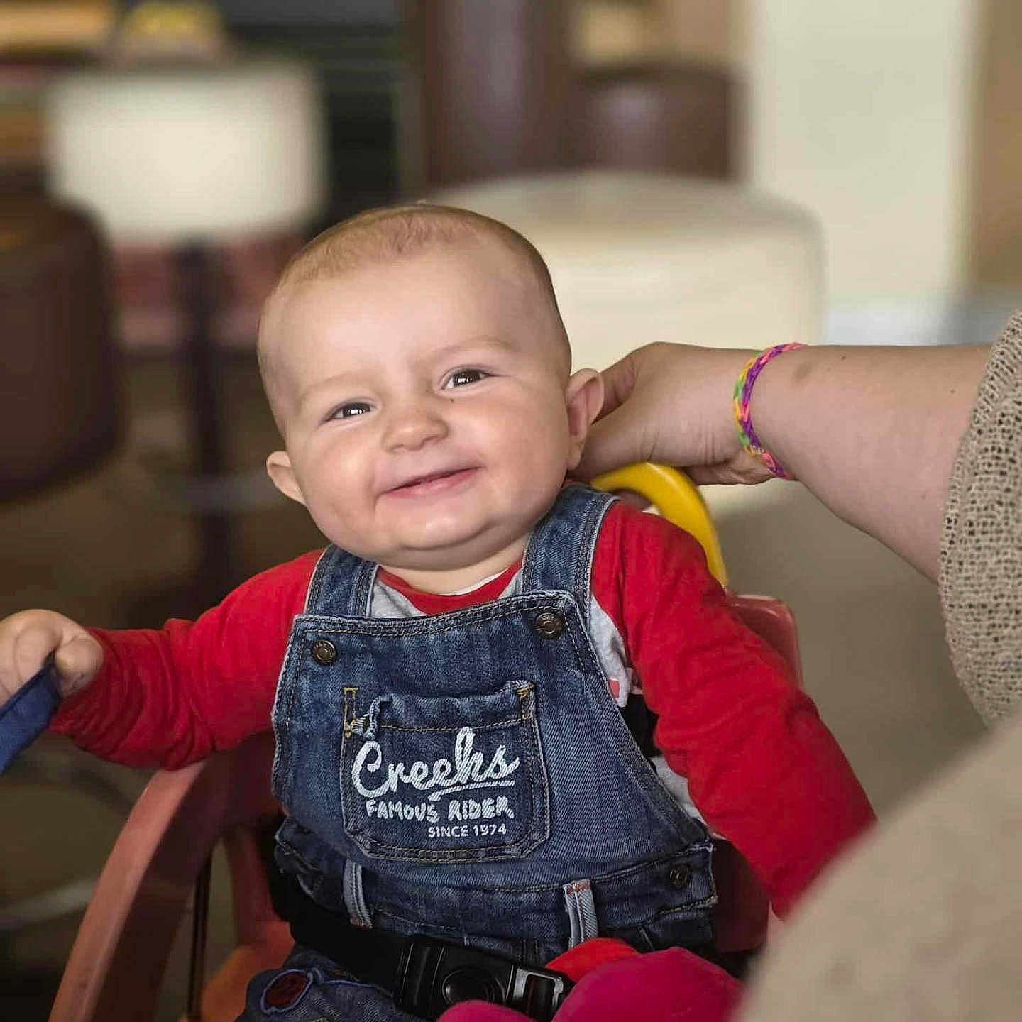 Helio participe au concours pour gagner de l'argent avec cette photo : baby, casual_clothing, child, cute, denim_overalls, face, furniture, hand, happy, high_chair, indoor, person, plush_toy, portrait, red_shirt, seated, smiling, support, toy, young_child