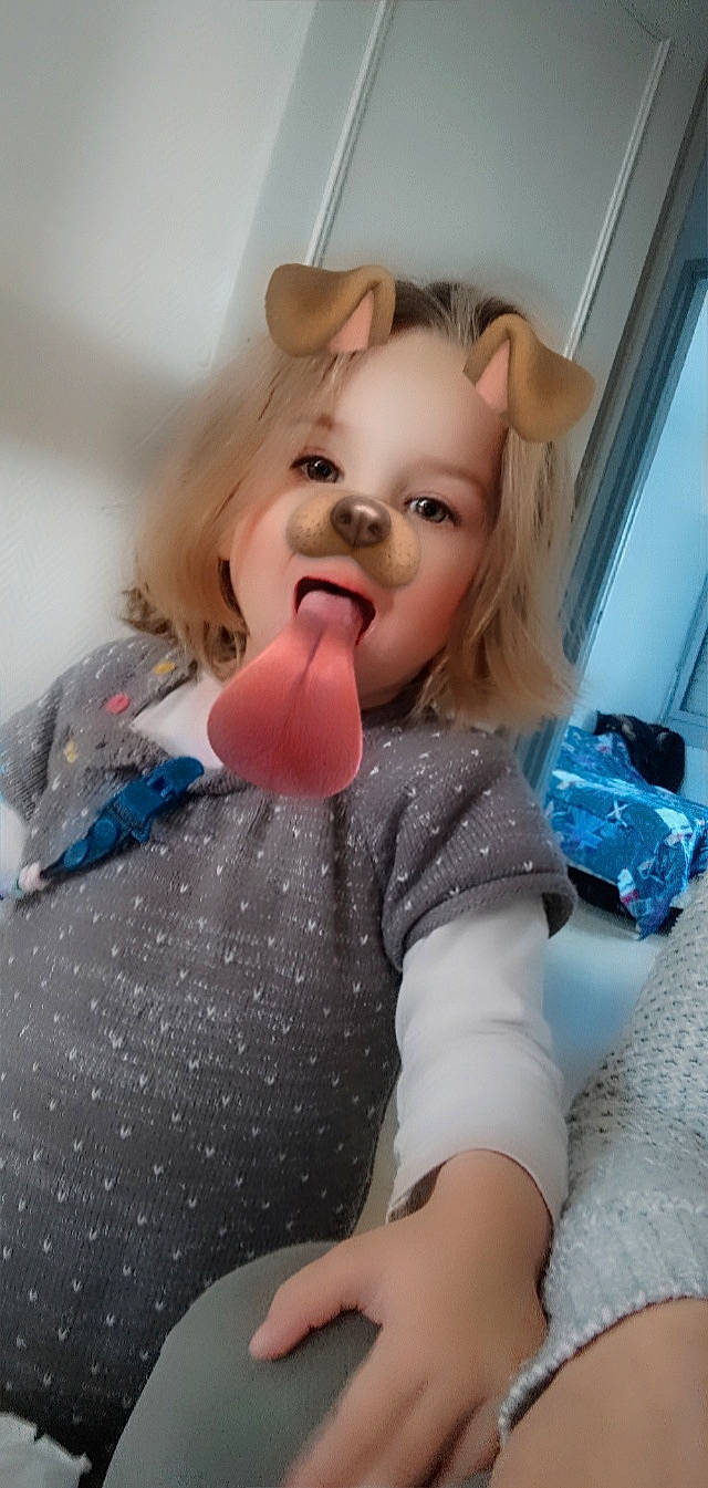 Lyloo participe au concours pour gagner de l'argent avec cette photo : baby_toddler_clothing, blond, child, doll, dress, eyelash, fashion_accessory, fun, gesture, happy, human_body, iris, lip, nose, pattern, person, pink, sleeve, smile, textile