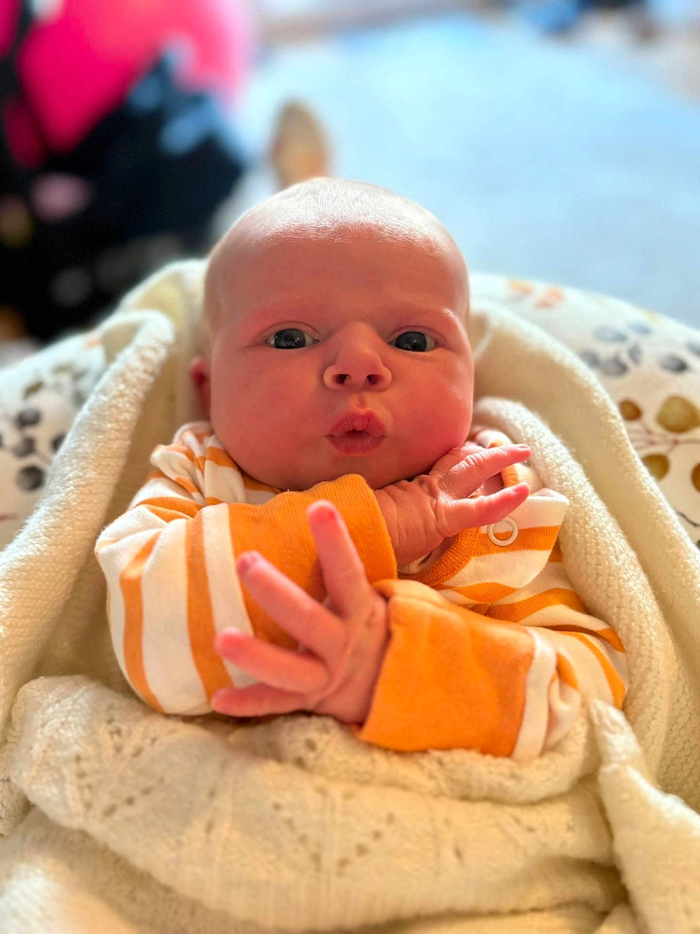 Ava joined the competition — help win amazing prizes! baby, infant, face, hands, blanket, clothing, orange_stripes, expression, cute, newborn, wrapped, cozy, portrait, indoor, soft_light, skin, person, closeup, warm, child