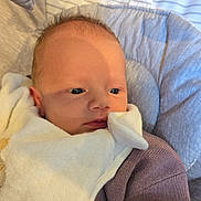 Samantha is registered to the contest to win money with this photo: baby, infant, blanket, purple_sweater, cushion, striped_fabric, face, eyes, clothing, newborn, soft_texture, indoor, resting, closeup, child, portrait, warm, cute, person, young
