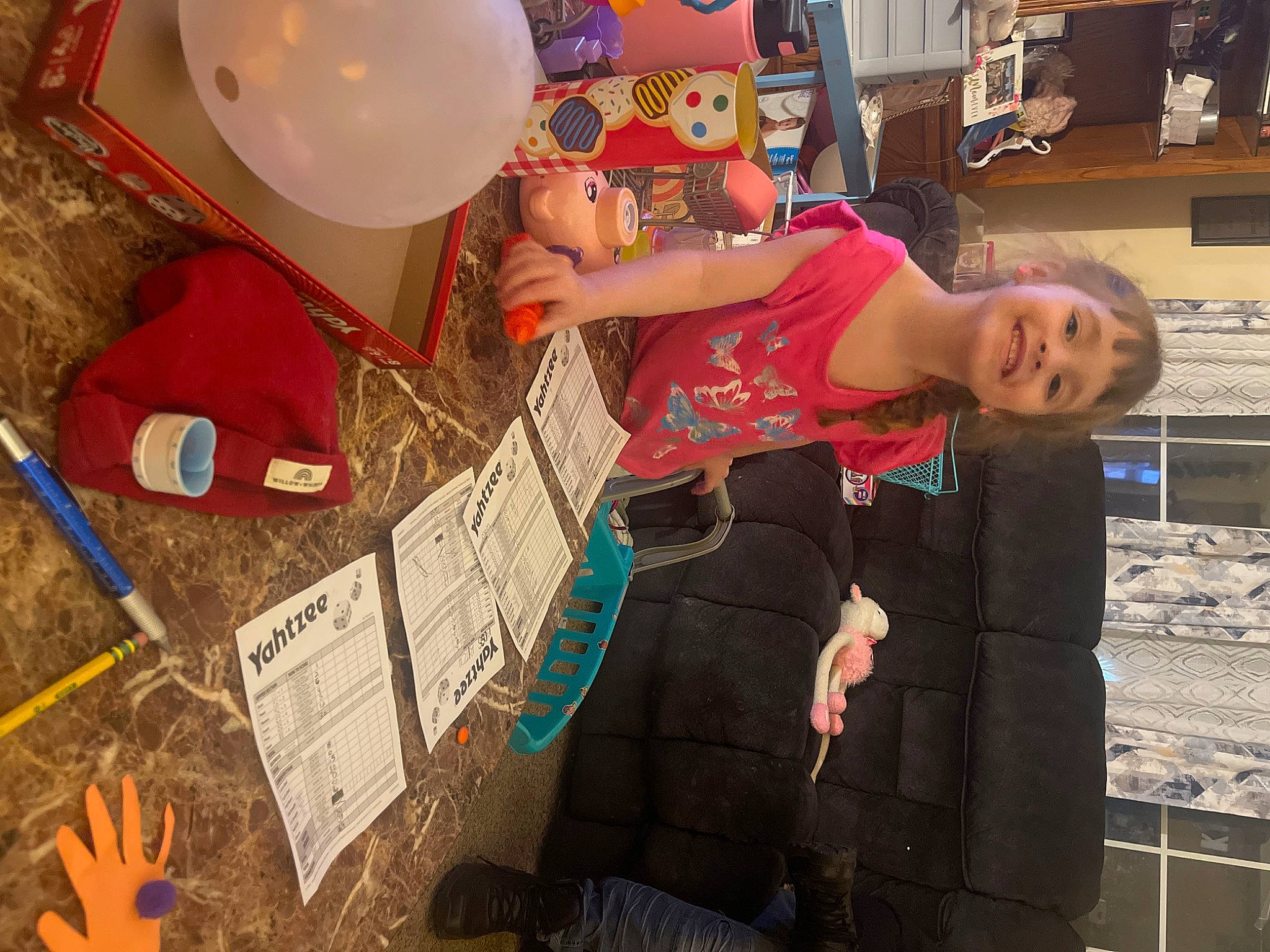Thea is registered to the contest to win money with this photo: balloon, bowl, cardboard, child, event, fun, hat, joy, leisure, party_supply, person, photograph, plastic, retail, room, shelf, snapshot, sun_hat, tableware, toddler