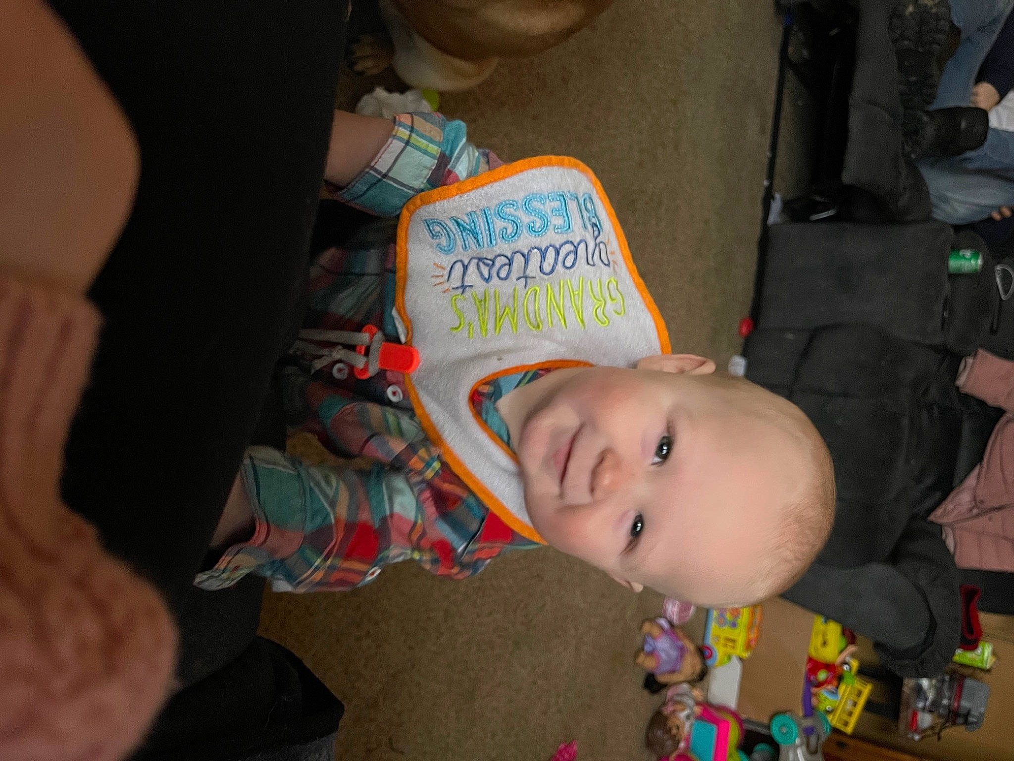 Theo is registered to the contest to win money with this photo: baby, baby_products, baby_toddler_clothing, cheek, child, ear, flooring, forehead, fun, handwriting, happy, head, mouth, nose, organ, person, sitting, skin, smile, t_shirt