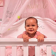 Miabelle is registered to the contest to win money with this photo: baby, crib, smile, pink, nursery, canopy, blanket, toy, child, infant, happy, person, bedroom, furniture, interior, cute, holding, standing, home, decor