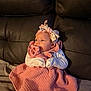 Catalina is registered to the contest to win money with this photo: baby, infant, pacifier, headband, pink_dress, sitting, couch, leather, blanket, white_sleeves, cute, indoors, child, young, portrait, comfortable, soft_lighting, cozy, hands_together, looking_away
