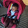 baby, bicycle, black_hair, brown_pants, car_seat, casual_clothing, child, garage, indoor, person, red, resting, safety, seat, socks, straps, thoughtful, tiled_floor, toddler, white_shirt