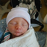 Issic is registered to the contest to win money with this photo: newborn, baby, sleeping, hat, blanket, hospital, medical, infant, face, closeup, peaceful, indoors, person, cute, child, swaddled, headwear, resting, newborn_baby, soft