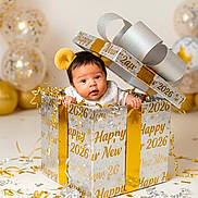 Elias Mateo joined the competition — help win amazing prizes! baby, gift_box, new_year, celebration, confetti, balloons, headband, yellow, silver, gold, cute, infant, party, holiday, festive, smiling, face, child, indoors, decorations
