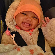 Ro'Miyah joined the competition — help win amazing prizes! baby, infant, smiling, beanie, hood, blanket, car_seat, pacifier, cozy, fuzzy_coat, hand, tongue, teeth, portrait, closeup, candid, warm_clothing, patterned_blanket, smile, straps