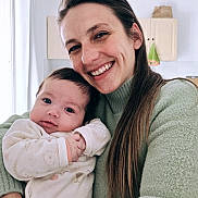 Léa participe au concours pour gagner de l'argent avec cette photo : baby, adult, smiling, portrait, indoor, kitchen, sweater, long_hair, holding, cuddle, closeup, happy, parent, infant, face, eyes, cozy, home, clothing, person