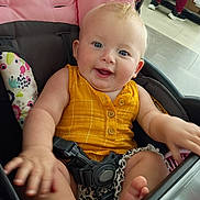 Jaeleah is registered to the contest to win money with this photo: baby, child, infant, smiling, happy, blue_eyes, blonde_hair, stroller, car_seat, sitting, yellow_clothing, romper, barefoot, toes, hand, portrait, indoor, shopping_center, patterned_fabric, safety_harness