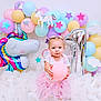 Khloe is registered to the contest to win money with this photo: baby, balloon, bathing, bathtub, clothing, dress, face, fun, hat, head, indoors, party, people, person, photography, playarea, portrait, sitting, sphere, tub