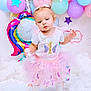 Khloe is registered to the contest to win money with this photo: baby, balloon, bodypart, clothing, costume, dress, face, finger, fun, hand, hat, head, party, people, person, photography, portrait, purple, skirt, sphere