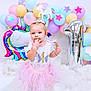 baby, balloon, bodypart, bread, clothing, dress, face, finger, food, fun, hand, hat, head, party, people, person, photography, portrait, purple, sitting