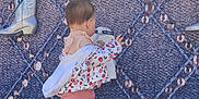 Freyja is registered to the contest to win money with this photo: toddler, child, pink_clothing, jacket, leggings, sneakers, boots, wall_display, patterned_background, outdoor, curious, walking, back_view, footwear, pavement, young_child, casual_clothing, baby, exploring, decorative