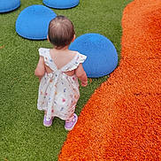 Freyja is registered to the contest to win money with this photo: toddler, child, dress, purple_shoes, playground, colorful, green_surface, orange_surface, blue_domes, brown_dome, outdoor, grass_like_surface, back_view, young_child, play_area, soft_play, cute, small_child, walking, summer_clothing