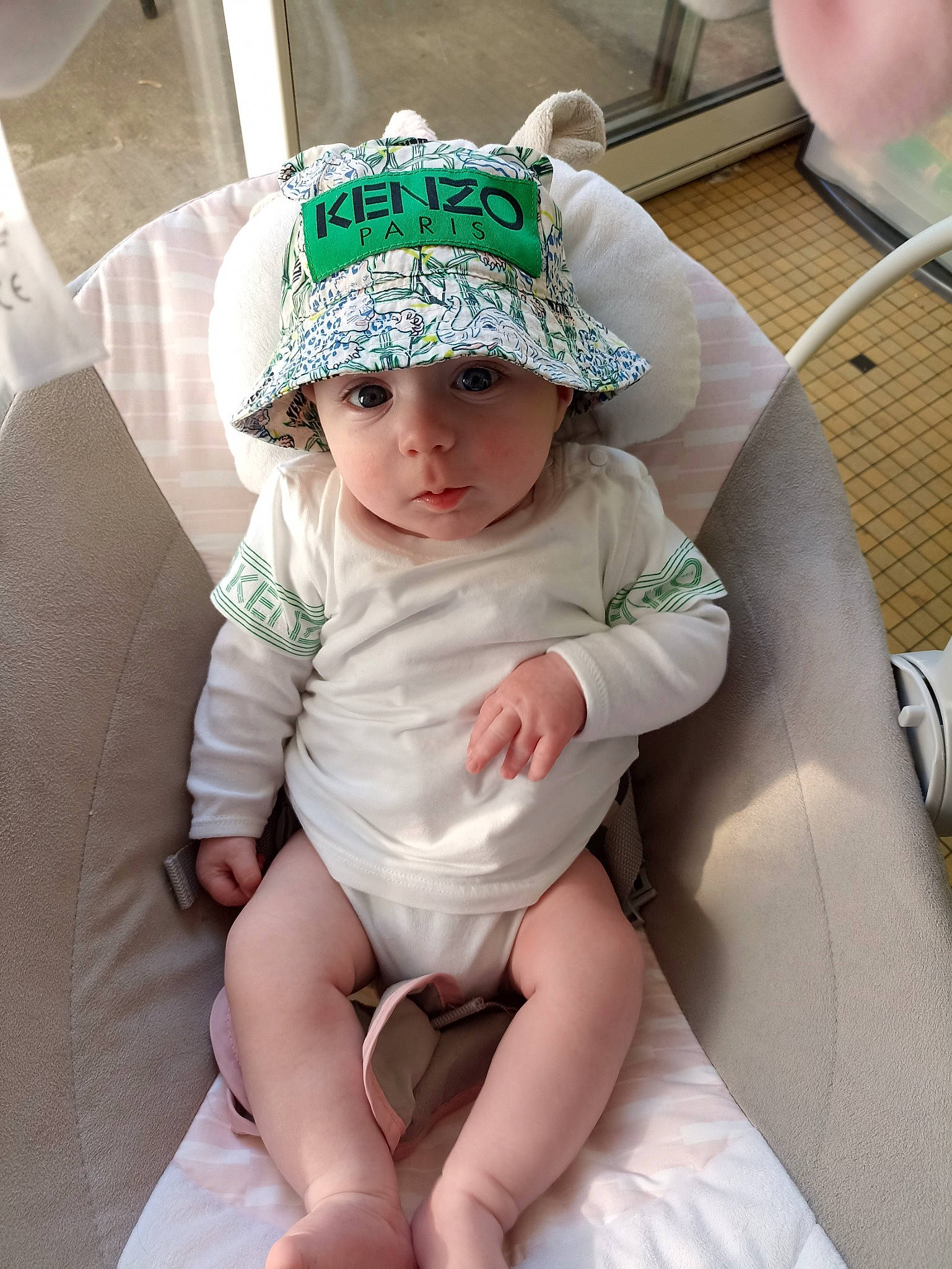 Paco participe au concours pour gagner de l'argent avec cette photo : baby, baby_toddler_clothing, cap, chair, child, comfort, dress, eye, fashion_accessory, foot, happy, hat, headband, headpiece, headwear, human_leg, knee, person, sitting, thigh