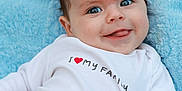 Isaac joined the competition — help win amazing prizes! baby, blue_blanket, blue_eyes, child, closeup, cozy, cute, face, happy, infant, lying_down, person, portrait, red_heart, smiling, soft_blanket, text_on_clothing, tongue_out, white_shirt, young