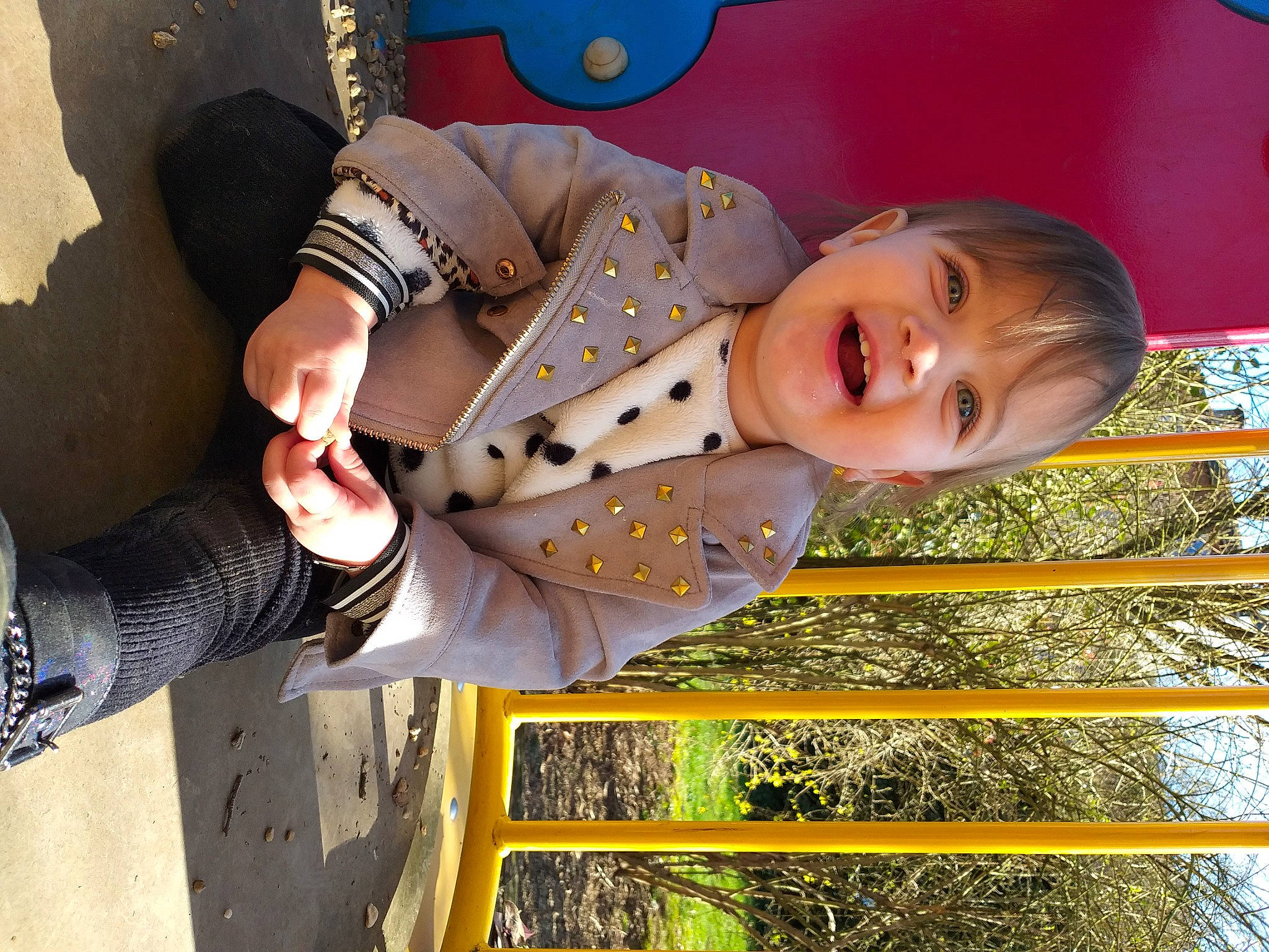 Joyce a rejoint le concours — aidez-le/la à gagner de superbes lots ! baby, baby_toddler_clothing, blue, child, fun, gesture, grass, happy, leisure, pattern, people_in_nature, person, play, sitting, sleeve, smile, street_fashion, toddler, tree, wood