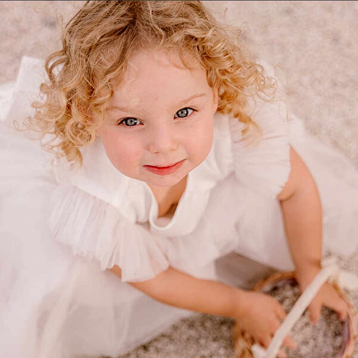 Noami a rejoint le concours — aidez-le/la à gagner de superbes lots ! basket, blonde, child, childhood, close_up, curly_hair, cute, face, girl, hands, happy, innocent, looking_up, outdoor, portrait, sitting, smile, soft_lighting, white_dress, young