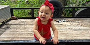 Jo Eva is registered to the contest to win money with this photo: toddler, child, red_headband, red_top, jeans, outdoor, deck, wooden_floor, metal_railing, greenery, trees, building, smiling, standing, cute, casual_clothing, daylight, nature, playful, baby_shoes