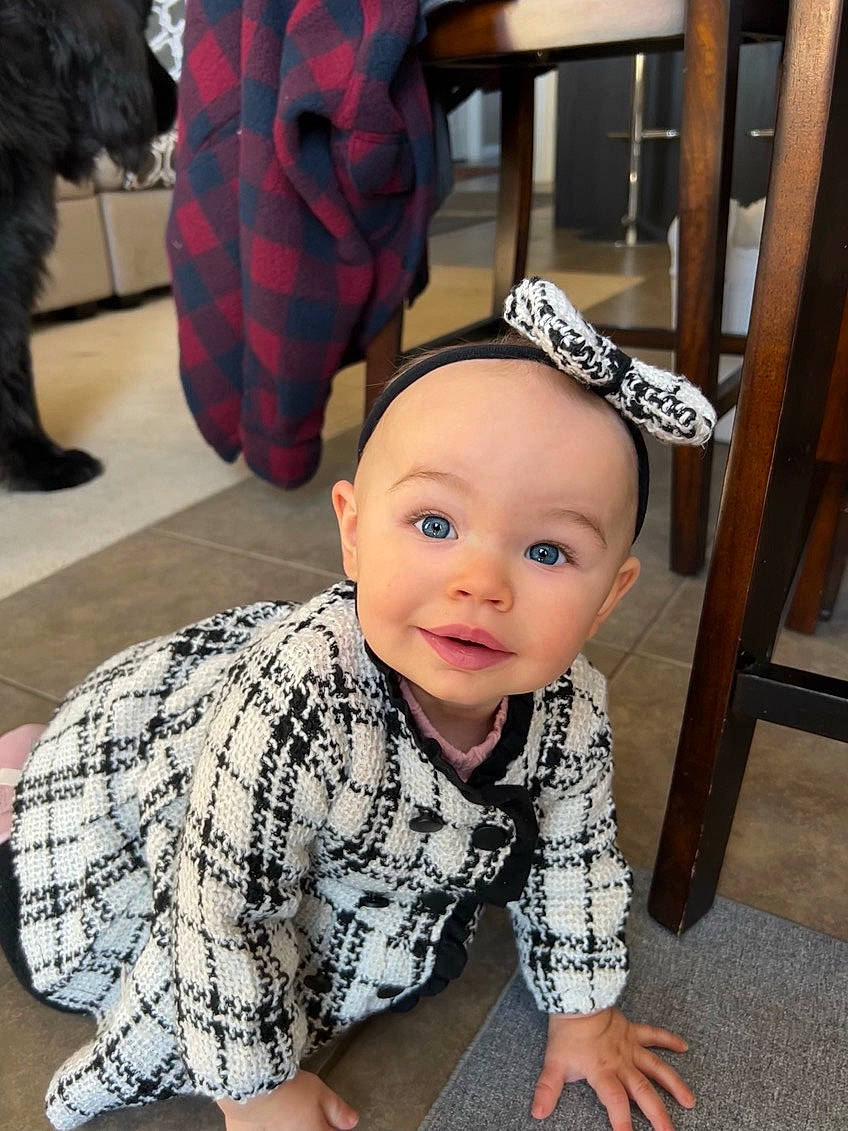 Celine is registered to the contest to win money with this photo: baby, baby_toddler_clothing, black, child, floor, flooring, fun, fur, happy, mammal, outerwear, pattern, person, red, sitting, sleeve, smile, t_shirt, toddler, vertebrate