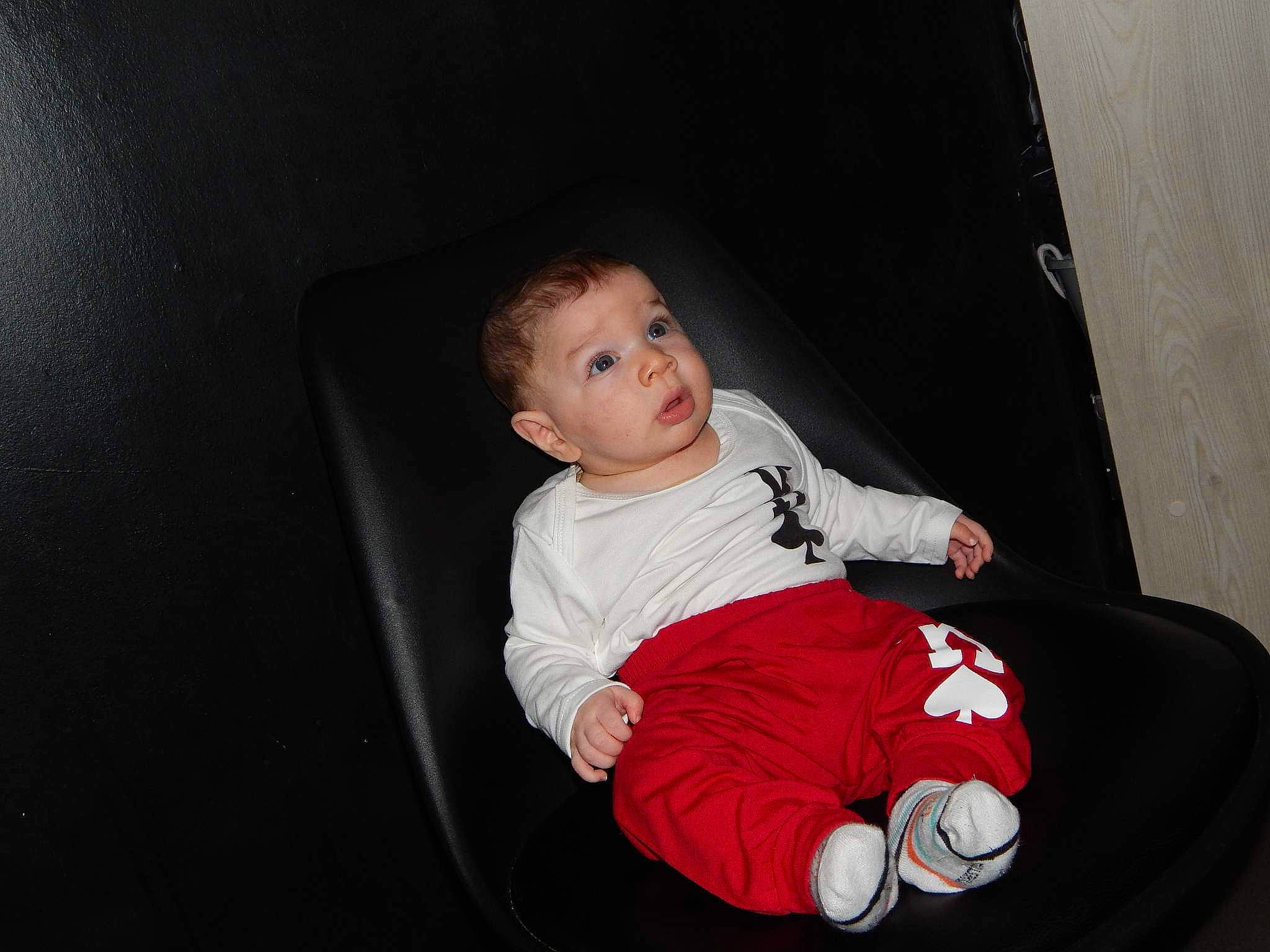 Rayden participe au concours pour gagner de l'argent avec cette photo : auto_part, baby, baby_toddler_clothing, carmine, cheek, child, comfort, darkness, elbow, flash_photography, fun, human_body, lap, leg, person, room, sitting, sleeve, sock, t_shirt