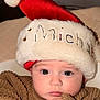 Michael joined the competition — help win amazing prizes! baby, child, face, santa_hat, knit_sweater, toy, indoor, portrait, closeup, cute, holiday, christmas, red_hat, white_fur, hand, eyes, expression, warm_lighting, soft_skin, cozy