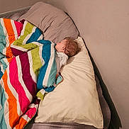 Aryatanner is registered to the contest to win money with this photo: baby, bed, bedding, bedroom, blanket, child, colorful, cozy, curly_hair, home, indoors, infant, nap, peaceful, pillow, portrait, resting, sleeping, soft_lighting, striped_blanket