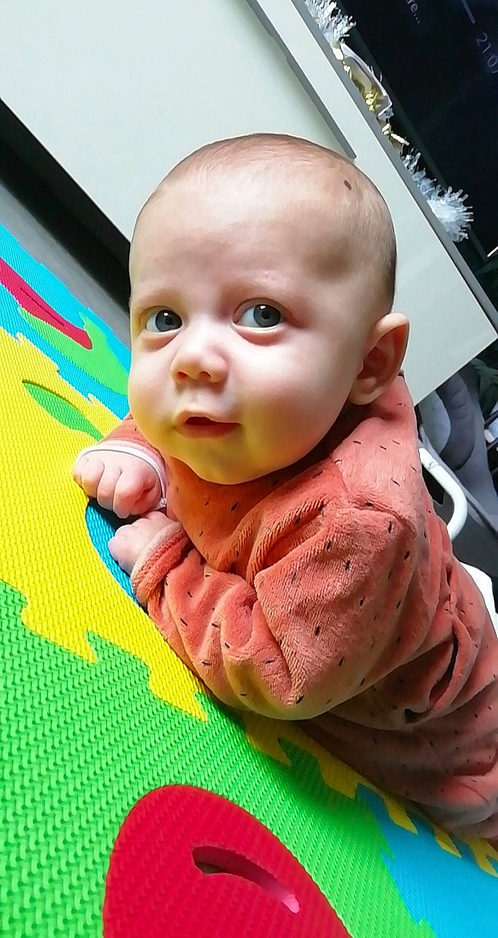 Lyad participe au concours pour gagner de l'argent avec cette photo : baby, baby_products, baby_toddler_clothing, bib, cheek, child, flooring, fun, grass, happy, leisure, linens, lip, nose, pattern, person, sitting, skin, toddler, vacation