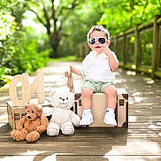 Mylan joined the competition — help win amazing prizes! casual_clothing, child, cute, greenery, one, outdoor, pathway, portrait, shoes, shorts, stuffed_animal, suitcase, summer, sunglasses, sunlight, teddy_bear, toddler, white_shirt, wooden_deck, wooden_letters