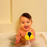Davud is registered to the contest to win money with this photo: toddler, bath, bathtub, bubbles, rubber_duck, child, happy, smile, water, play, toy, indoors, skin, head, face, small_child, fun, clean, splash, cute
