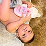 Davud joined the competition — help win amazing prizes! baby, infant, bottle, lotion, towel, floor, carpet, child, skin, hand, face, eyes, indoor, cute, holding, person, young_child, care, product, relaxing