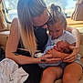 affection, baby, blonde_hair, casual_clothing, child, couch, curtain, embrace, family, holding, indoor, intimacy, legs, love, natural_light, newborn, skin, tattoo, window, woman