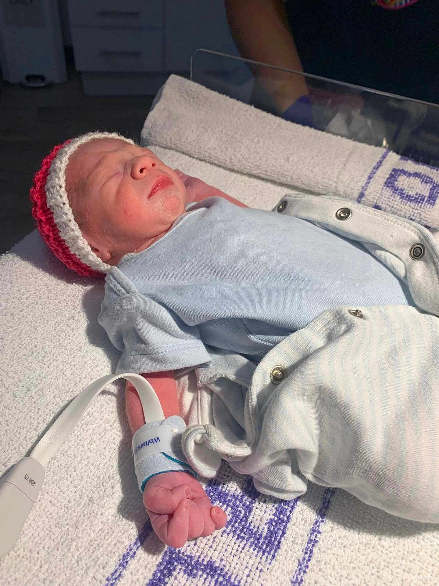 Ronnie joined the competition — help win amazing prizes! newborn, baby, infant, hospital, blanket, clothing, hat, medical_wristband, monitoring_device, sleeping, peaceful, healthcare, person, bed, towel, hospital_room, cute, small, skin, rest