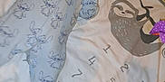 Ronnie is registered to the contest to win money with this photo: baby, sleeping, onesie, milestone_blanket, sloth, numbers, toy, colorful, infant, cute, peaceful, child, soft, blanket, pattern, cartoon, lying_down, indoors, playmat, newborn