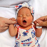 Addison is registered to the contest to win money with this photo: newborn, baby, infant, yawning, headband, holding_hands, adult_hands, white_background, cute, sleeping, toddler_clothing, colorful_outfit, closeup, human, skin, portrait, baby_fashion, small_hands, resting, lying_down