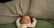 Greyson is registered to the contest to win money with this photo: baby, sleeping, bed, blanket, pillow, infant, child, rest, cozy, peaceful, indoors, person, sleepwear, comfort, relaxation, yoga_pose, soft_lighting, cute, toddler, nap