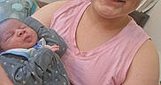 Elijah is registered to the contest to win money with this photo: child, newborn, baby, sibling, infant, portrait, smiling, sleeping, 抱抱, holding, family, indoor, pink_shirt, gray_onesie, star_pattern, arms, cuddling, face, cozy, photograph