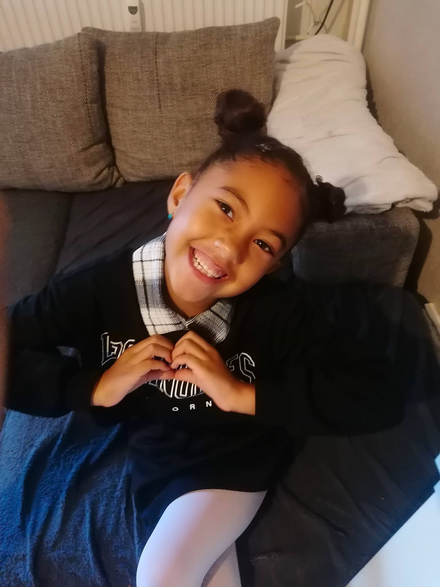 Emmy participe au concours pour gagner de l'argent avec cette photo : chin, comfort, couch, elbow, eye, flash_photography, furniture, hair, happy, head, human_leg, joint, joy, knee, leg, neck, person, pillow, sitting, smile