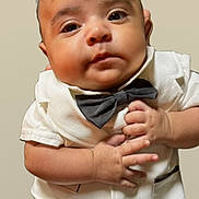 Zohan is registered to the contest to win money with this photo: adorable, baby, bow_tie, child, close_up, cute, expression, eyes, face, fashion, formal_wear, hands, infant, person, portrait, skin, studio, toddler, white_suit, young_child