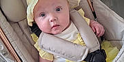 Delilah Denise is registered to the contest to win money with this photo: baby, baby_accessories, baby_clothing, blue_eyes, child, curious_expression, fabric, flooring, hand, headwear, indoor, infant, pale_skin, person, plush_toy, seat_belt, soft_toys, stroller, yellow_dress, yellow_hat