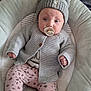 baby, baby_nest, blanket, cardigan, child, comfortable, cozy, cute, indoor, infant, knit_hat, pacifier, patterned_leggings, pillow, pink_leggings, portrait, resting, socks, soft_fabric, warm_clothing