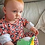 baby, child, infant, plush_toy, stuffed_animal, couch, sofa, pink_clothing, animal_print, indoor, face, person, video_call, screen, hand, sitting, expression, hair, adult, woman