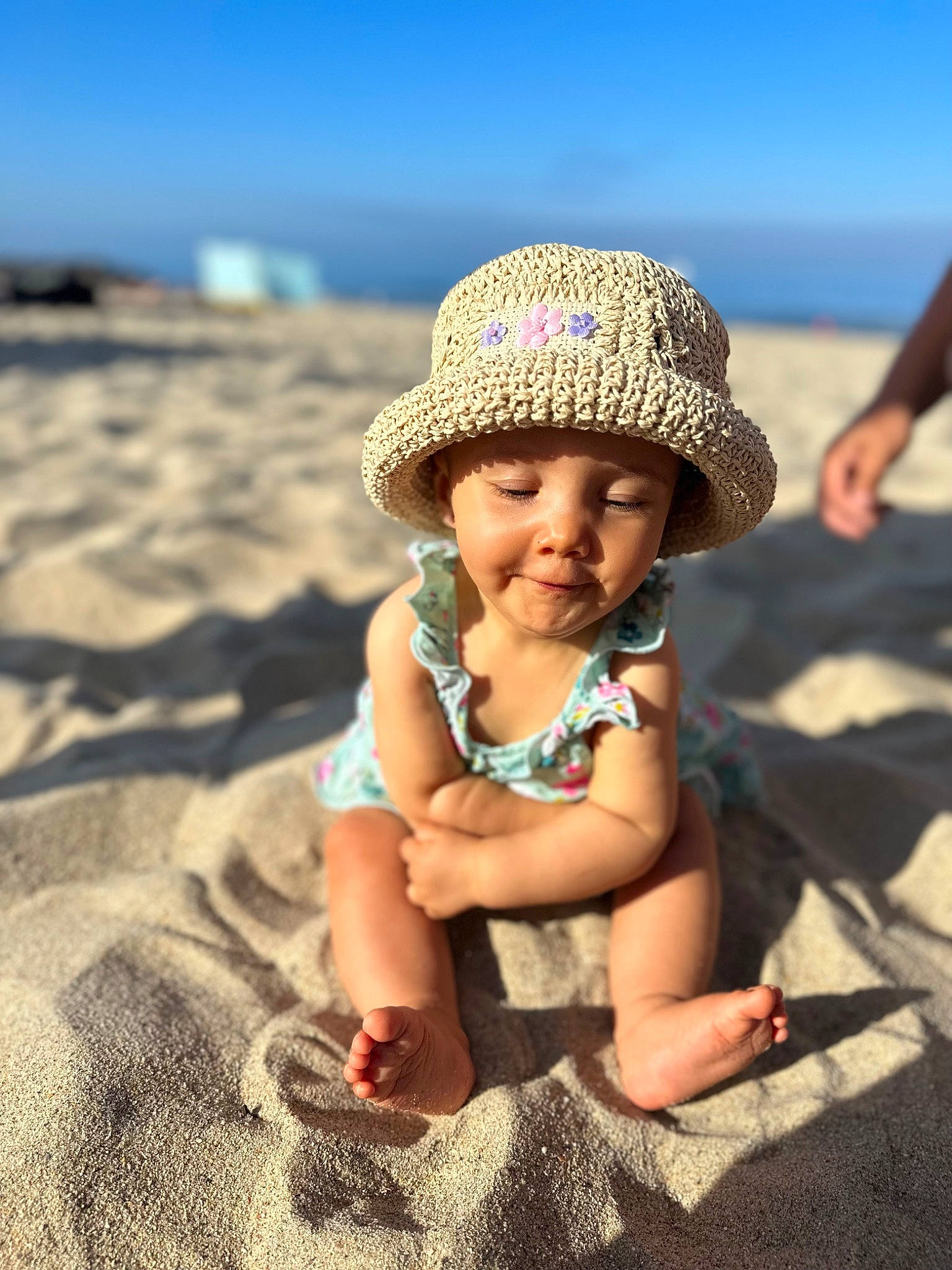 Romy participe au concours pour gagner de l'argent avec cette photo : azure, beach, body_of_water, cap, fun, grass, hand, happy, hat, headgear, headwear, landscape, leisure, morning, people_in_nature, person, sky, sun_hat, sunlight, toddler