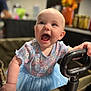 baby, child, tutu, blue, floral, clothing, smile, happy, wagon, handle, hand, face, cute, joyful, indoor, portrait, person, infant, expression, candid